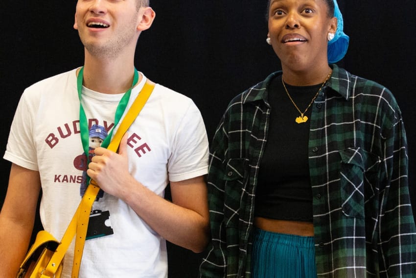 Isaac and Chileya in rehearsals – the two actors stand side by side against a black background at the edge of some lockers. They both look slightly up in wonder.